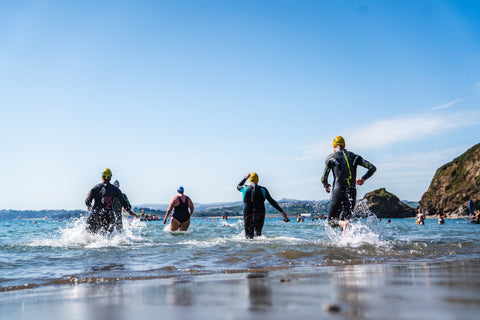 Group of Open water swimmers heading in to the sea