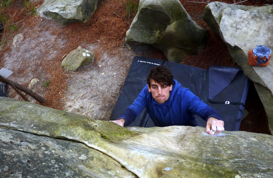 boulderer going for the top in fontainebleau