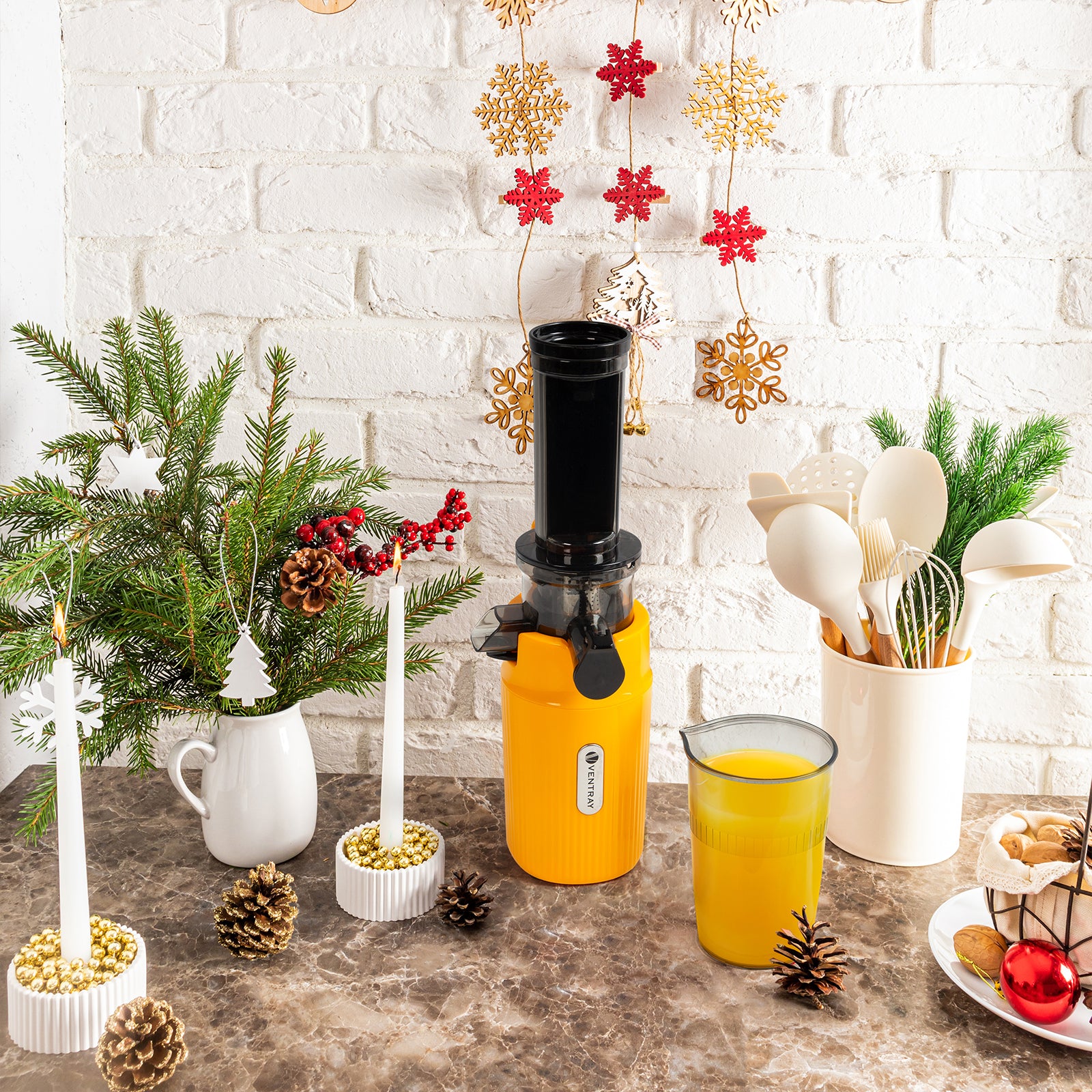 Ventray Yellow Ginnie Juicer is on the table, next to juice, candle and Christmas decoration