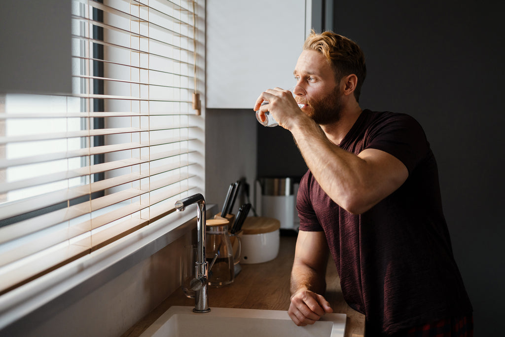 fit-man-in-the-kitchen-drinking-filtered-water