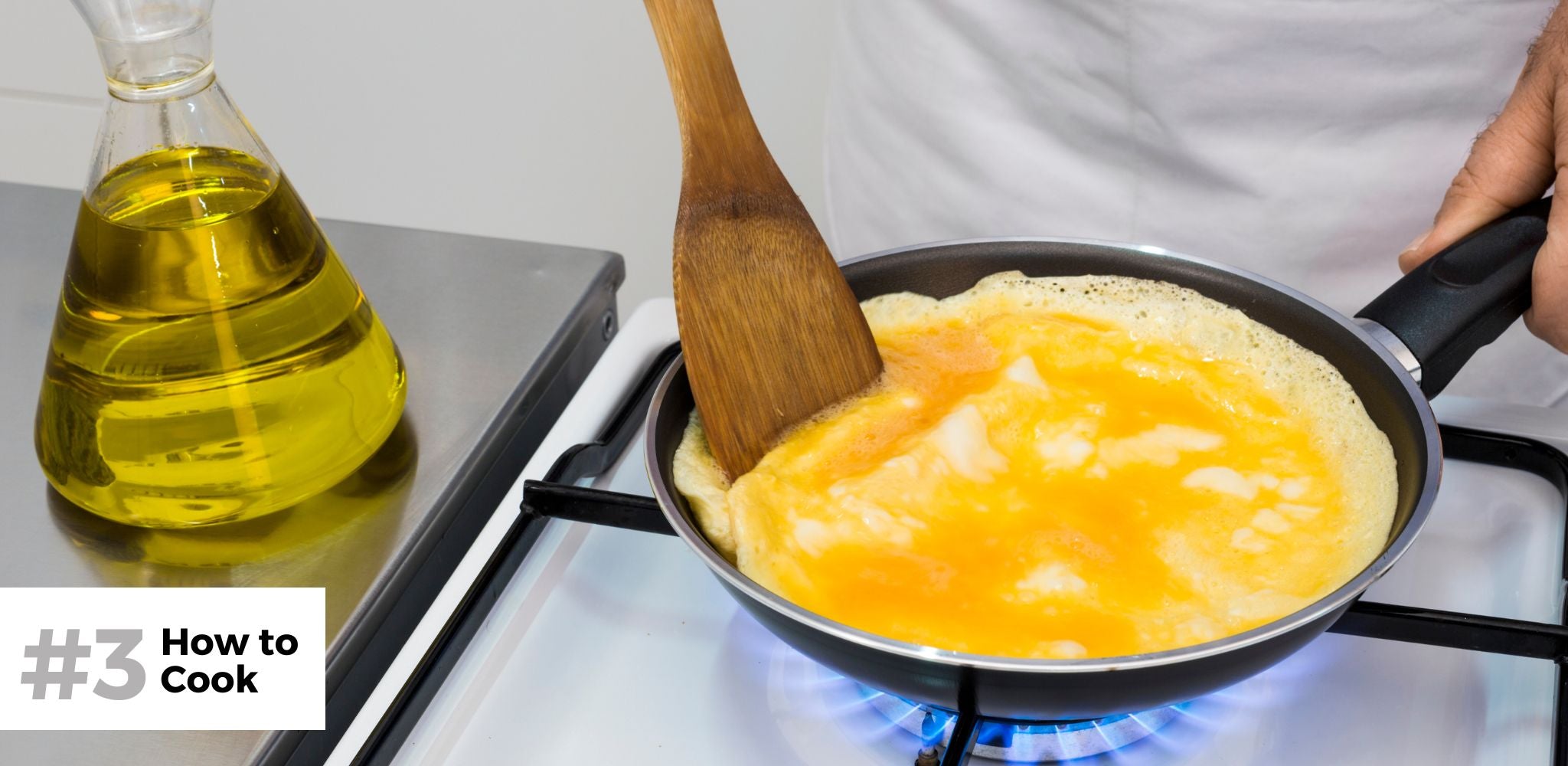 Creating the perfect omelet in a non stick skillet with a bottle of olive oil on the side