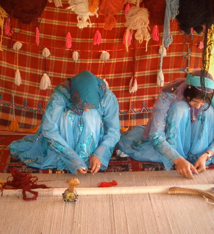 Qashqai weavers hand-knotting a rug
