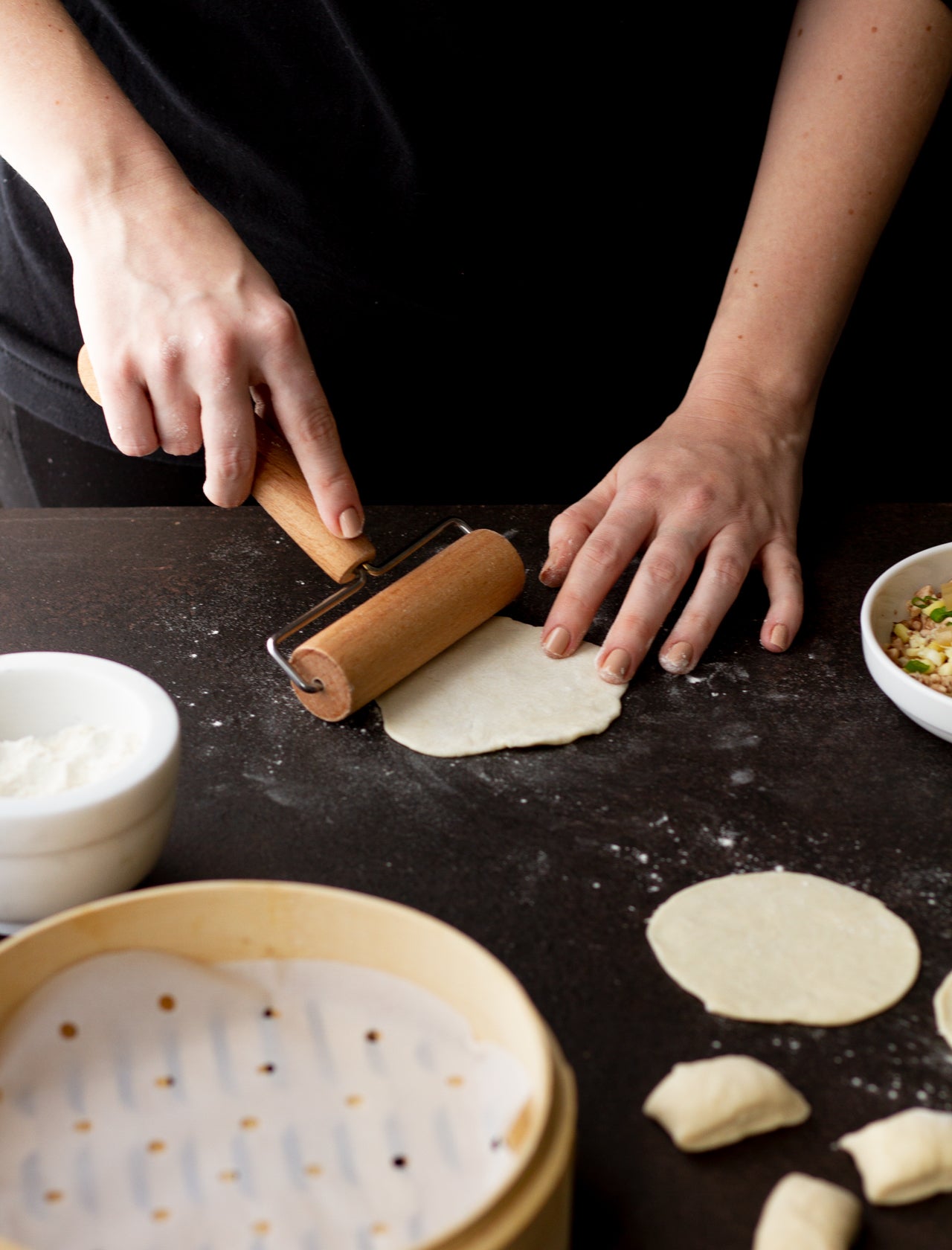 rolling out chinese soup dumpling dough into wrappers