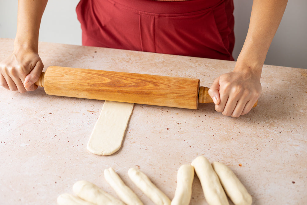 rolling each log flat with a rolling pin