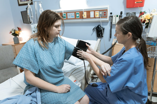 nurse taking patient's blood pressure in hospital