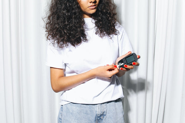 diabetic woman checking blood sugar level on device