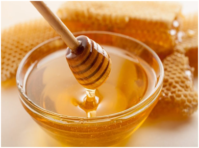 Raw honey in bowl next to honeycomb