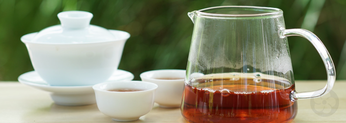Formosa Red Assam brewed in a porcelain gaiwan and served in a glass pitcher and white tasting cups
