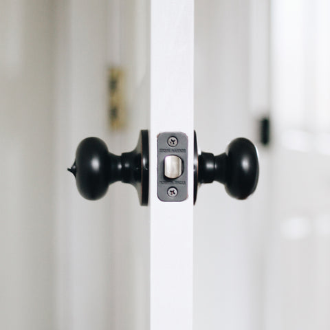 Highland Privacy Door Knob Viewed from the Edge of a Door Painted White