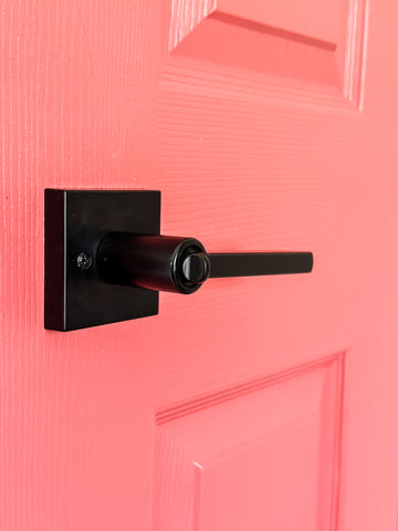 Matte Black Vienna Door Lever on a bright pink door