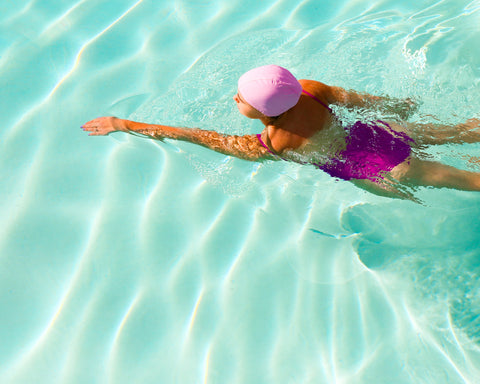 woman swimming while wearing swim cap