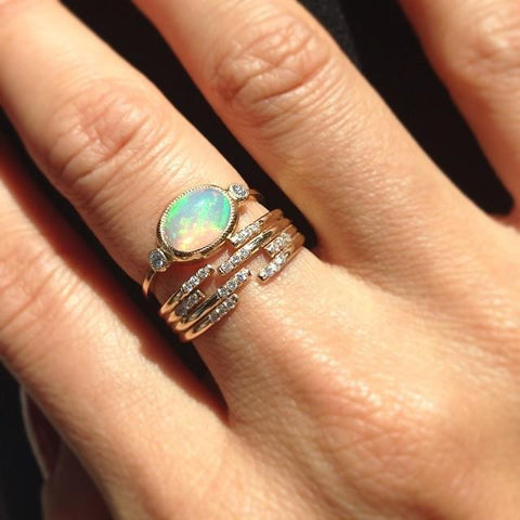 opal and gold rings on finger