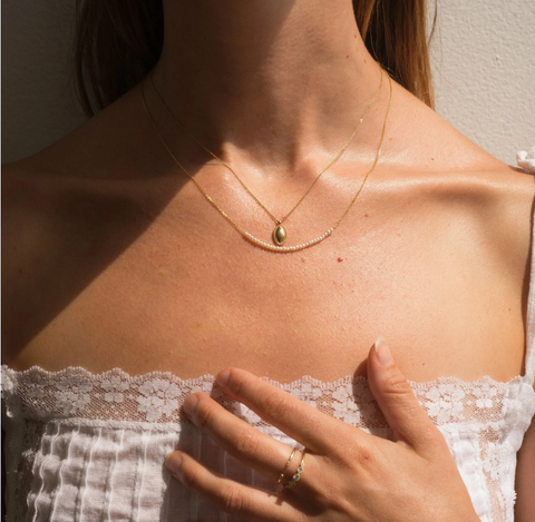 Pearl Arc Gold Necklace pictured on model with other jewelry