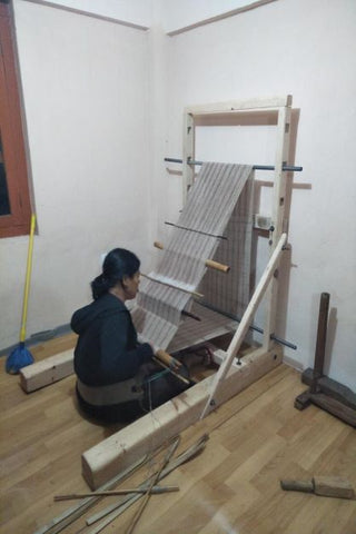 Backstrap weaver in front of the loom weaving throw cushions for artha collections