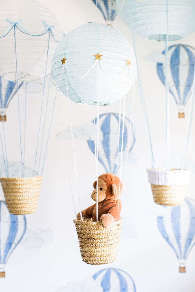 Boy's room interior decor with hot air balloons and blue wallpaper.