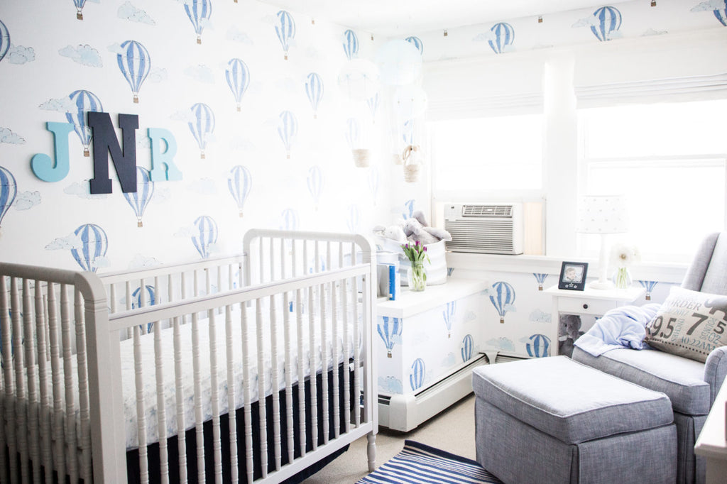 White crib in white and blue interior, boy's nursery styling.
