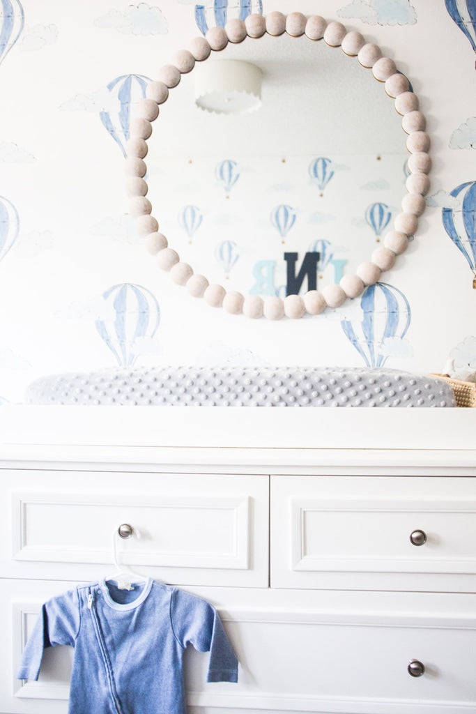 Boy's nursery interior in white, blue and grey with wooden accents.