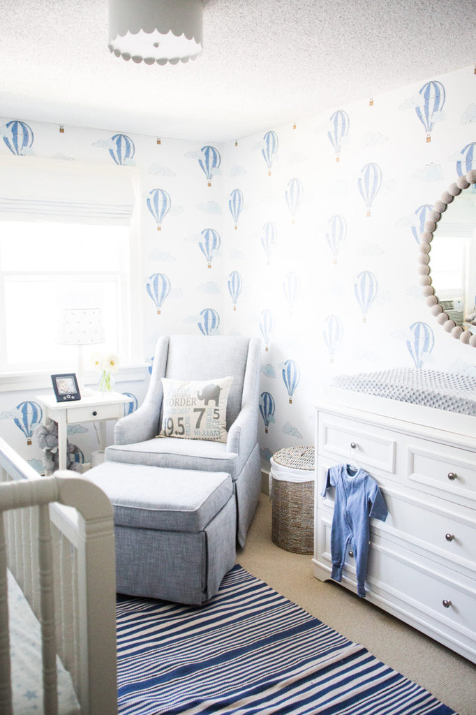 Boy's nursery with blue accents and white wood furniture.
