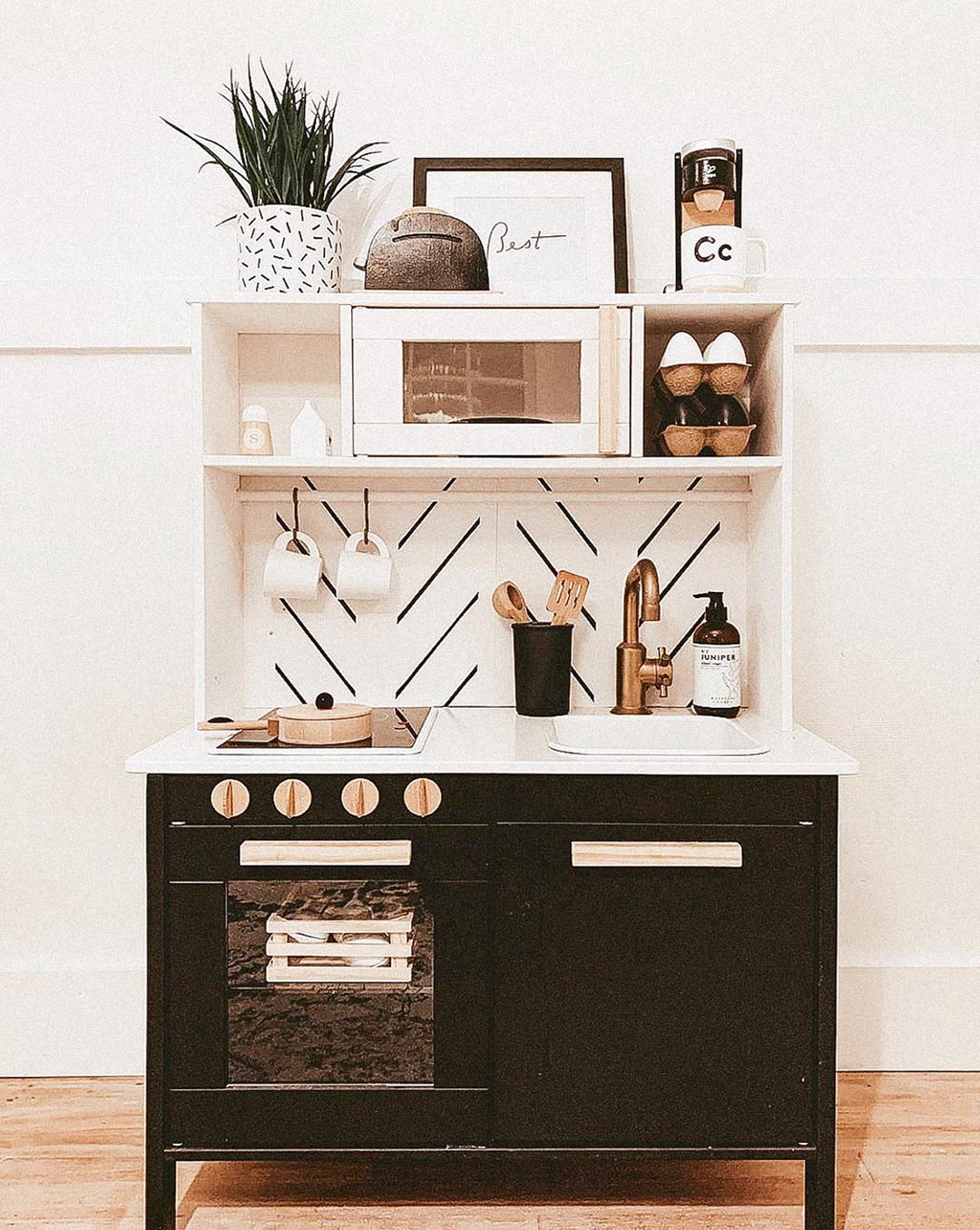 IKEA play kitchen DIY with modern herringbone removable wallpaper backsplash and black and brass kitchen hardware and decor