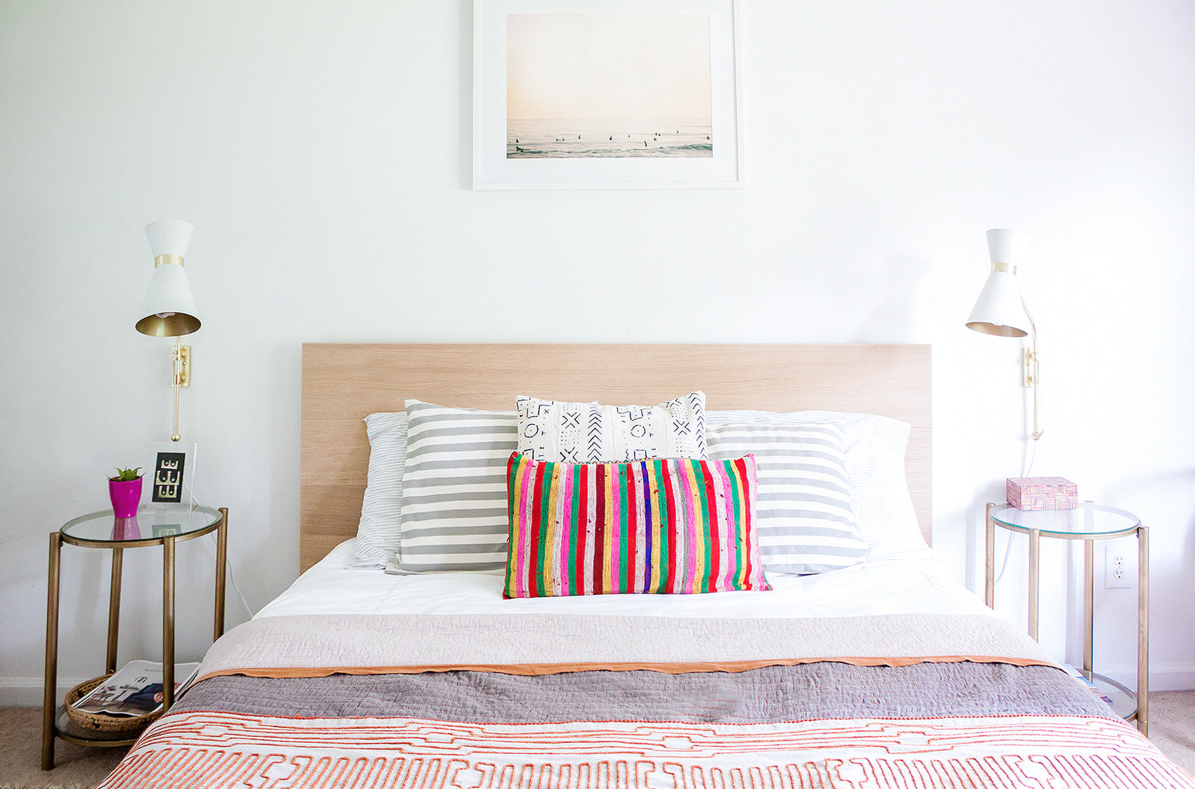 Simple master bed with colorful duvet and patterned cushions