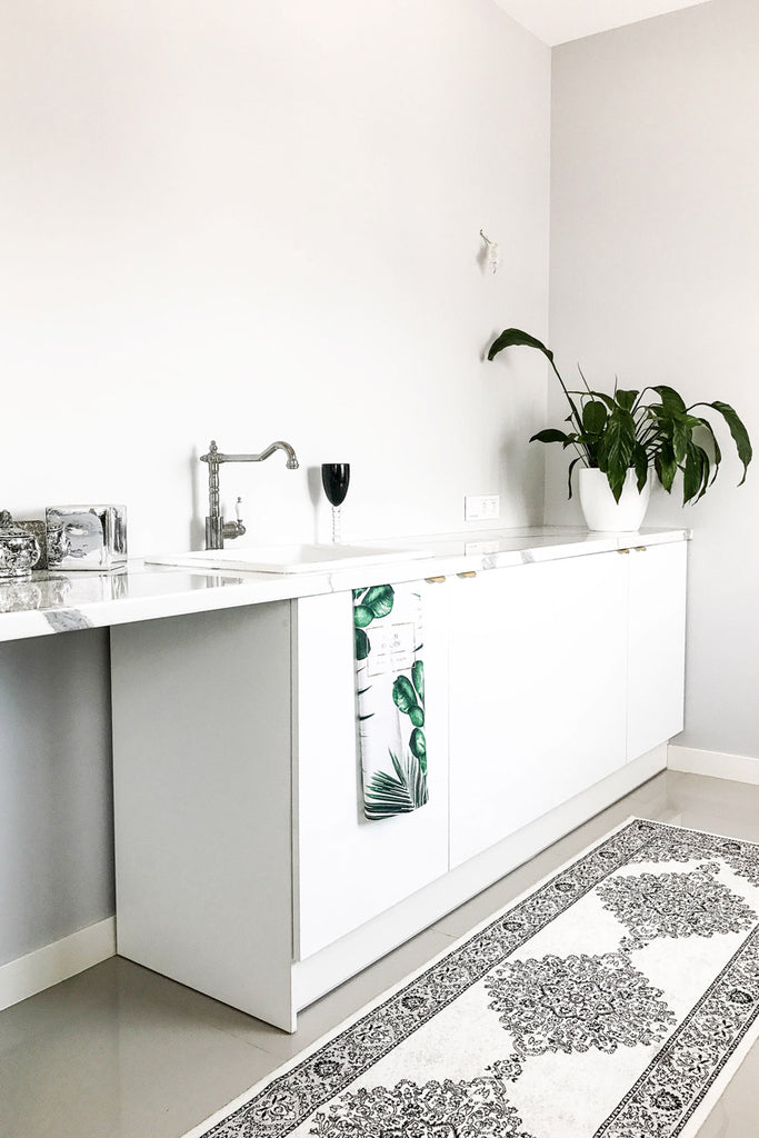 White office kitchen with light grey walls and white oriental rug