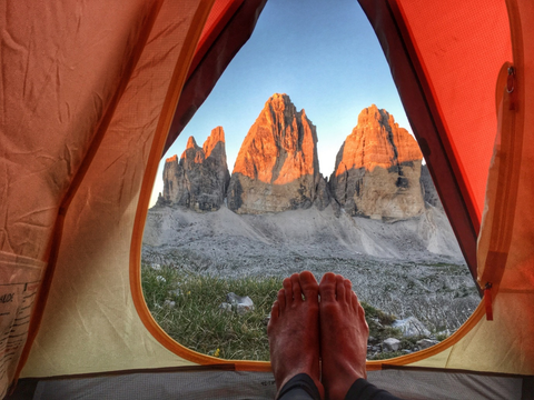 Person inside a tent near mountains