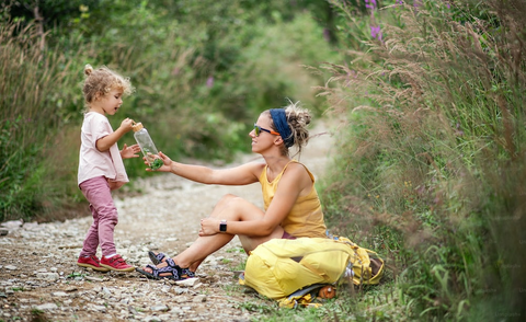 A woman giving water to a child