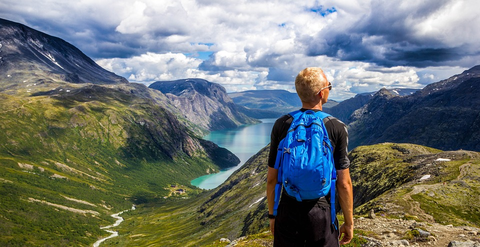 man wearing a hiking backpack in front of a scenery