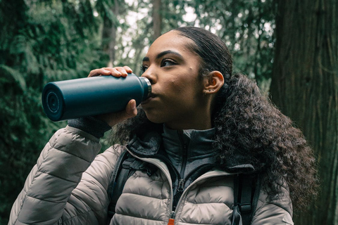 A woman drinking water during a hike