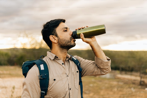 A person drinking water during a hike