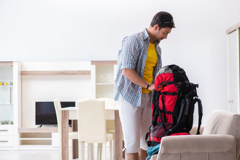 man packing hiking backpack