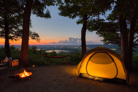 A camping tent next to a fire