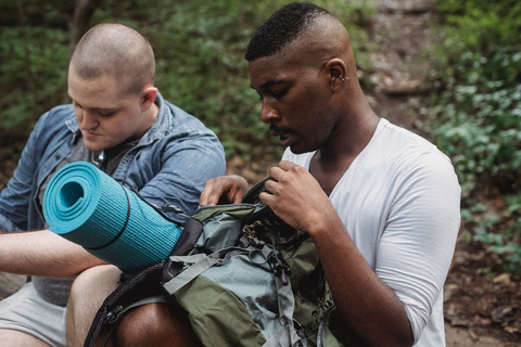 Hikers checking backpacks in woodland