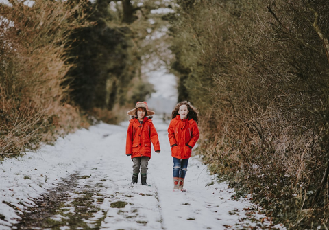Two kids on a trail covered with snow