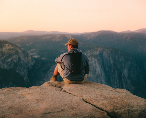 An explorer enjoying a mountain top view