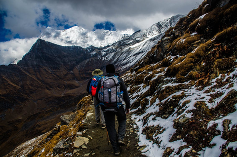 Two people backpacking on a snowy mountain