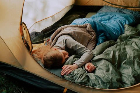 A person sleeping inside a camping tent