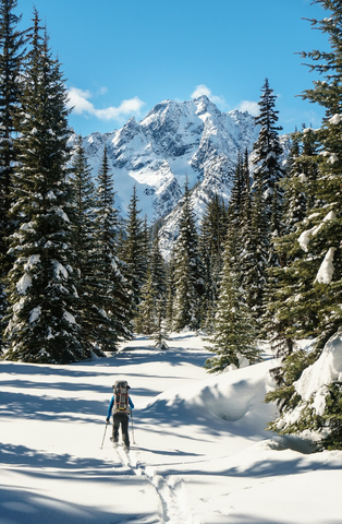 A skier walking toward a mountain top