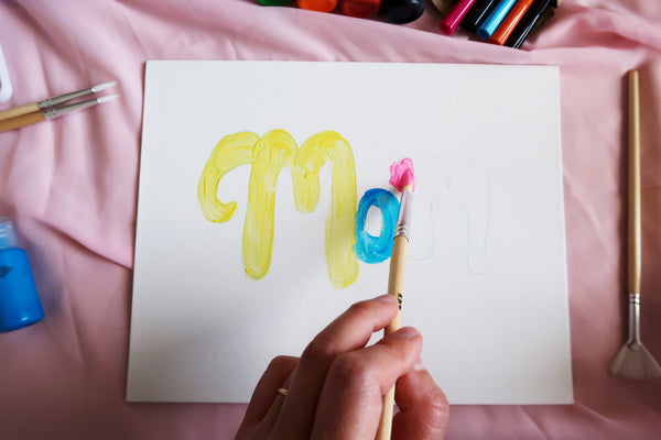 painting in the word mom on canvas