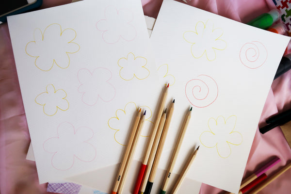 create outlines of flowers on watercolor paper with pencil
