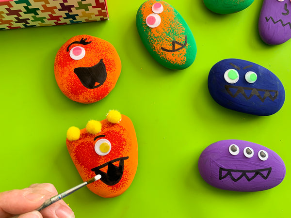 painting monster faces on rocks