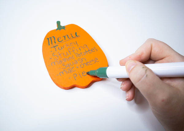 writing thanksgiving menu on wooden pumpkin