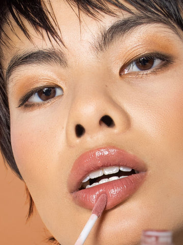 Asian Model Wearing Neutral Eyeshadow with Natural Foundation and Glossy Y2K LipGloss for Fall 2021 Makeup Trends