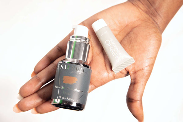 Open palm hand holding a bottle of PFAS Free Foundation and Sample Tube with a warm feeling