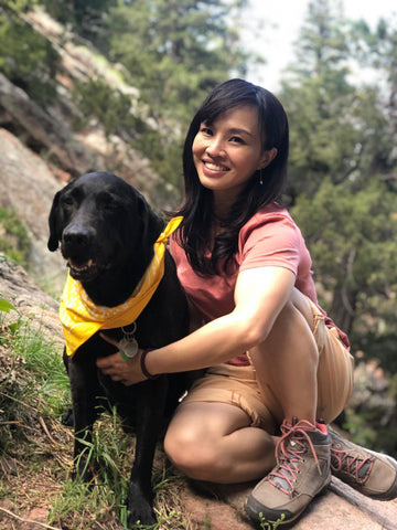 International Certified Yoga Trainer Heidi Chen with her dog on a mountain, taking a break while hiking
