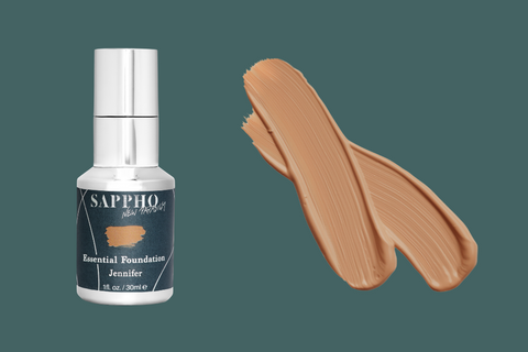 Essential Foundation bottle in Jennifer with swatch on green background