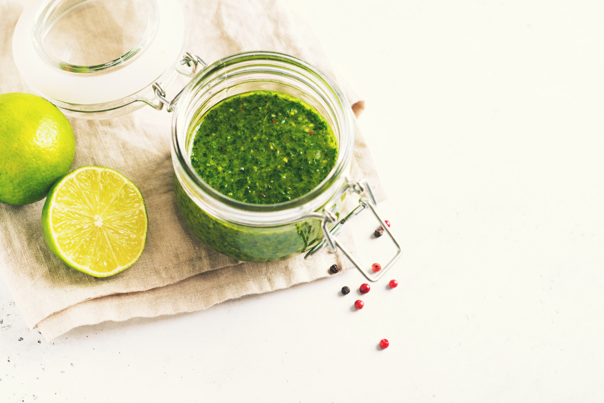 Chimichurri in small jar on white table