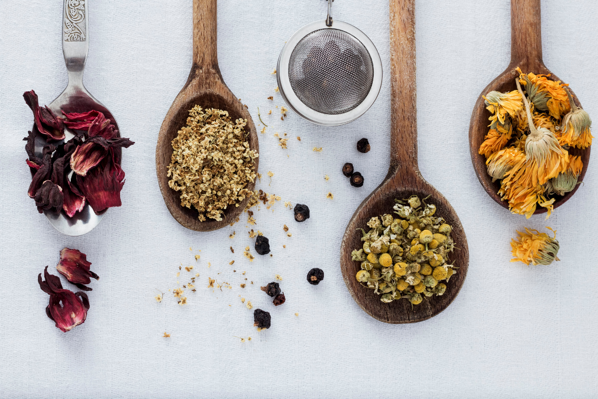 Spoons of Herbal Tea on white table