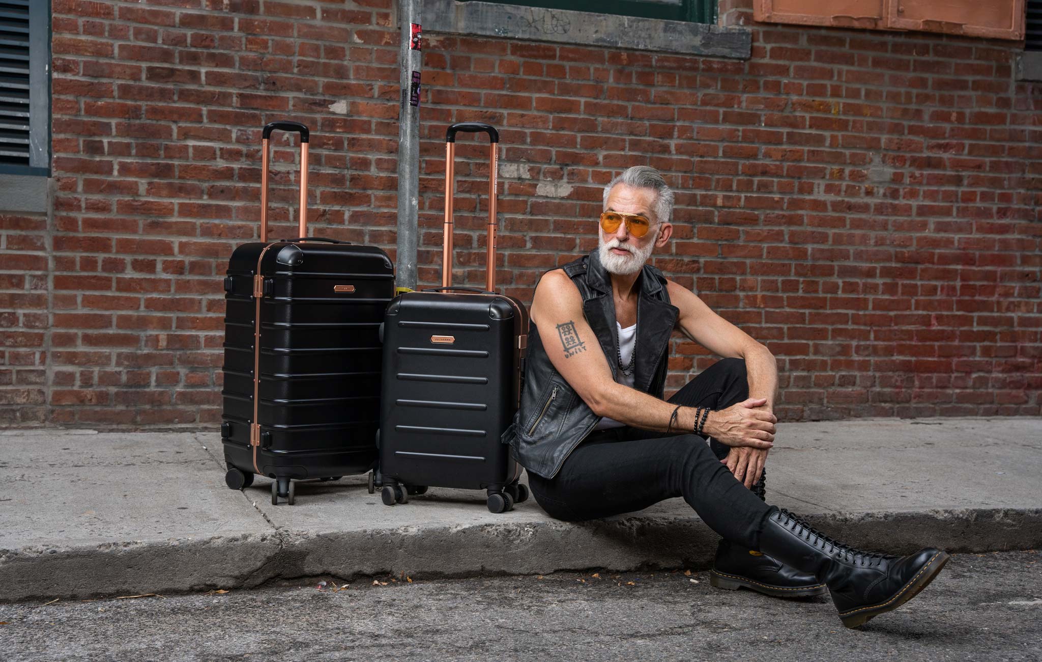 man with a carry on suitcase and a check in suitcase