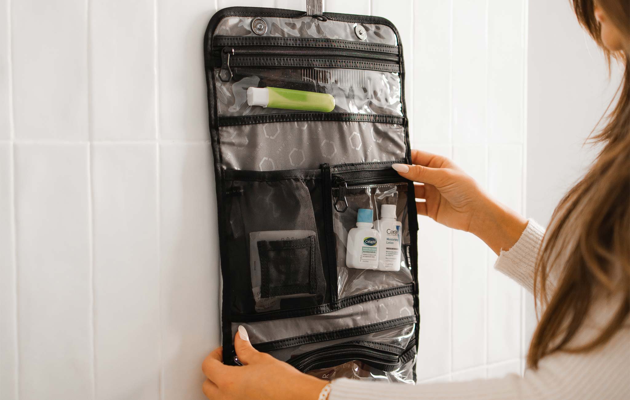 woman packing a solgaard hanging toiletry kit